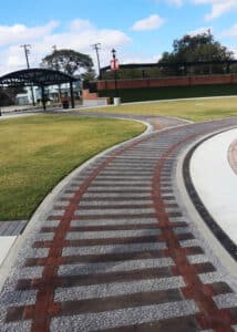 Train Track-themed paved path at Central Social District Park